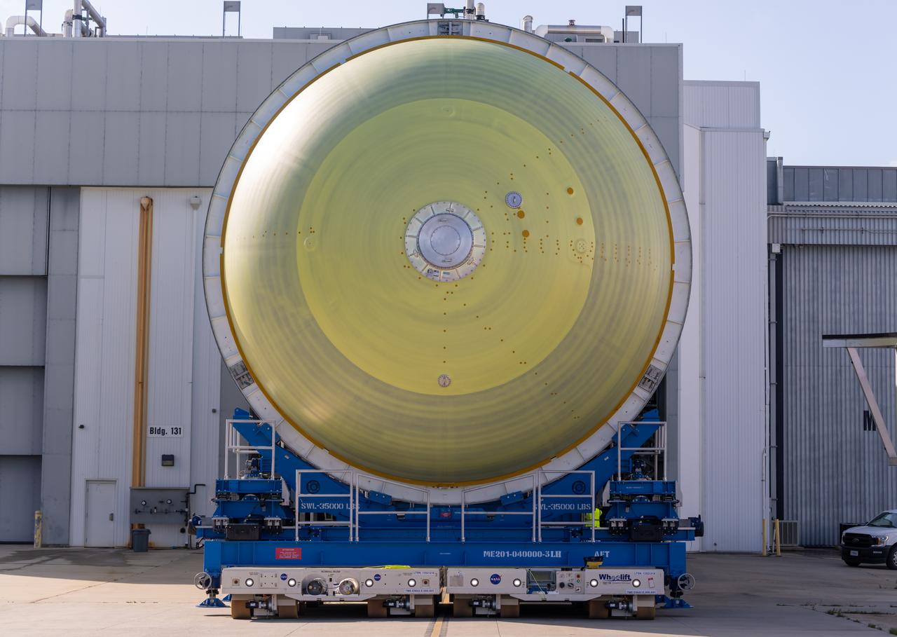 Teams move a liquid hydrogen tank for NASA’s SLS (Space Launch System) rocket out of a priming cell and into an adjacent cell on May 20 at the agency’s Michoud Assembly Facility in New Orleans. Inside the cell, the tank, which will be used on the core stage of NASA’s Artemis III mission, will receive its thermal protection system.  The thermal protection system, or spray-on foam insulation, provides protection to the core stage during launch. It is flexible enough to move with the rocket yet can withstand the aerodynamic pressures as the SLS accelerates from 0 to 17,500 mph and soars to more than 100 miles above the Earth. This third-generation insulation is more environmentally friendly and keeps the cryogenic propellant, which powers the rocket’s four RS-25 engines, extremely cold (the liquid hydrogen must remain at minus 423 degrees Fahrenheit/253 degrees Celsius) to remain in its liquid state. When applied the thermal protection system is a light-yellow color, which “tans” once exposed to the Sun’s ultraviolet rays, giving the SLS core stage its signature orange color.